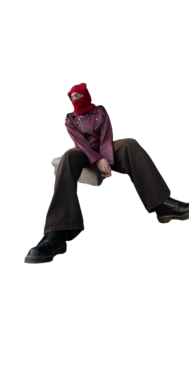 ARTA seated in a burgundy jacket and red knitted mask